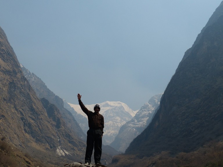 Man Standing Between Two Hills with Majestic Mountain Background